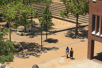 Students walk through the Forest Park courtyard, past the rectangular, concrete fountain, which hasn’t been turned on in years. Some people would like to see it spray water again. (Photo by Garrieth Crockett)