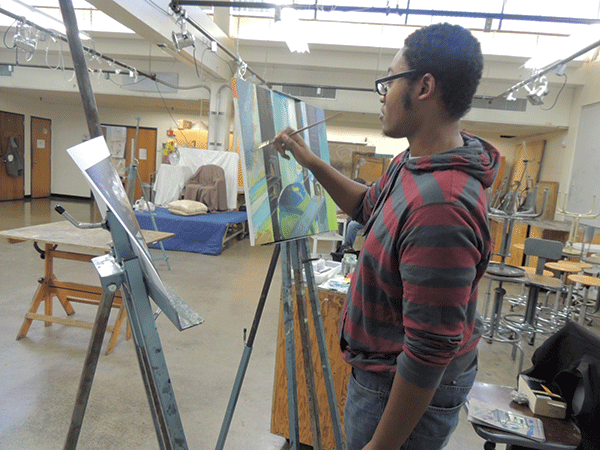 Fine arts student Darryl Reece, 19, works on an abstract landscape painting.  He is the Fine Arts Club treasurer. (Photo by Tina Albercino)