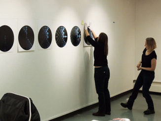 Artist Laura Mackin, right, and Art Department Chair Jamie Kreher hang Mackin’s pieces for the exhibit “Come Slowly, Eden” (Photo by Evan Sandel)