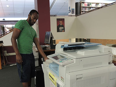 Elementary education major Steven Grath, 22, takes advantage of the free printing now available in the library. (Photo by  Quyen Huynh)