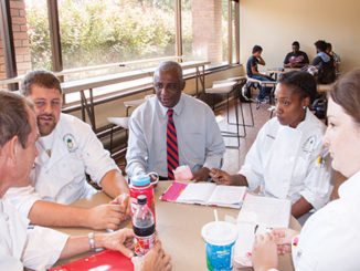 New Vice President Franklin Taylor, center, visits with culinary art students, clockwise, Tamekia Robinson, 35, Anylynn Myers, 21, George Hanson, 49, and Stephen Hacker, 24, in the cafeteria. (Photo by Tina Alberico)