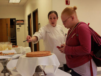 Jean Leatherich, 36, baking and pastry arts major, sells a cake to Michelle Kyles, 29, accounting major, in the Hospitality Studies building on a recent Wednesday. (Photo by Quyen Huynh)