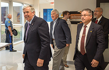 Gov. Mike Parson, left, and his security detail leave the Hispanic Leaders Group meeting at Forest Park after his speech on June 13. (Photo by Daniel Shular)