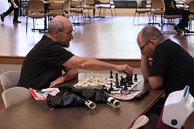 Copy Technician Tom Rogers, left, and Music Program Coordinator Tom Zirkle re-enact a game Tom Rodgers played in a championship in 1974, when the campus had an active chess team. (Photo by Garrieth Crockett)