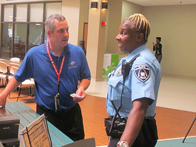 Campus police officer Teri Buford jokes with Todd Segneri in the cafeteria. (Photo by Chris Cunningham)