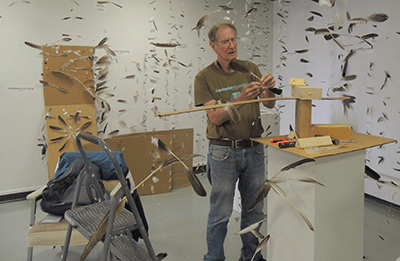 Artist Don Wilson hangs feathers on fishing line while installing his exhibit, “O’ to Fly Again,” which opens July 1 in the Gallery of Contemporary Art at Forest Park. (Photos by Yuanyuan Ji)