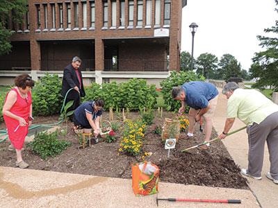 Faculty and staff tend to a butterfly garden outside A Tower in the summer of 2015.The space is now a construction site. (Photo by Chris Cunningham)