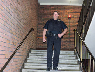 Forest Park police officer Davie Jost patrols an F Tower stairwell on the night shift March 4. He has radio contact with a dispatcher on the Florissant Valley campus. ( Photo by Timothy Bold)
