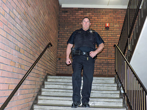 Forest Park police officer Davie Jost patrols an F Tower stairwell on the night shift March 4. He has radio contact with a dispatcher on the Florissant Valley campus. ( Photo by Timothy Bold)