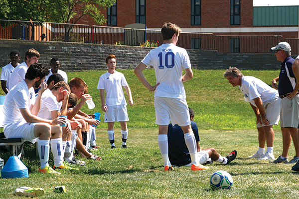 Coach Dan O’Keefe, second from right, gives instructions to the Archers men’s soccer team during a practice. (Photo by Julian Hadley)