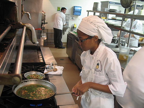 Culinary arts student Ciera Esty sautées green beans and walnuts on the industrial stove. (Photo by DeJuan Baskin)