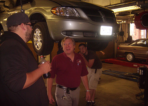 Richard Athens, center, chats with Erik Blankenship while Danny Borgers and John Wagner work on a serpentine belt. (Photo by DeJuan Baskin)