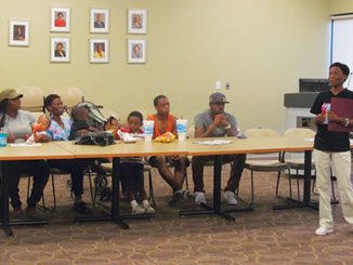 Ka’Chelle Morris, left to right, Tiffany Ransom, Konnell Wright, Joshua Stone and children listen to Ball’s mother, Toni Taylor, speak about her son’s shooting. (Photo by Chris Cunningham)