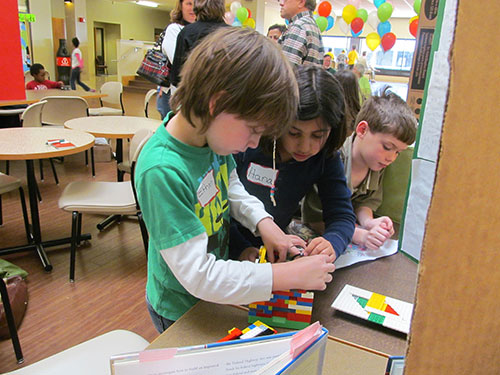 Ethan Coble, 8, Hana Noueriy, 8, and Andrew Burns, 9, work on their Lego machine. (Photo by Chris Cunningham)