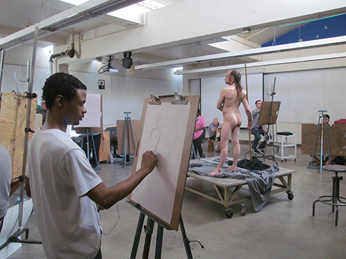 Graphic design major Raheem Hitchins, 23, draws model Eric Peniston, 47, in Figure Drawing I. (Photo by Chris Cunningham)