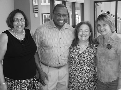 John Buckingham, center, poses with his wife, Minnie, and friends Kim Marie Hecht and Diane Geradot at his retirement party. (Photo by Jamie Greene)