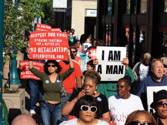 Protesters carry signs as they march on Delmar Boulevard.(Photo by Garrieth Crockett)