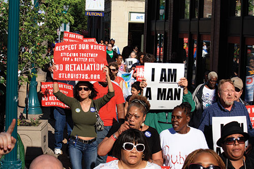 Protesters carry signs as they march on Delmar Boulevard.(Photo by Garrieth Crockett)