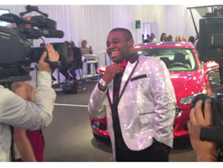Byron Keaton hams it up for the cameras in front of the red Ford Fusion he won in the Rolling with Ford contest. (Provided photo)