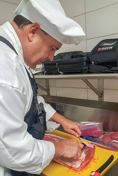 Culinary arts student Dave Jost cuts fat from steaks in class. (Photo by Angelica Woody)