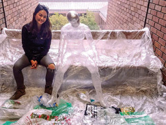 Fine arts student Christy Lin poses with her sculpture, “Reflecting on Creation,” on the fourth floor of G Tower. (Provided photo)