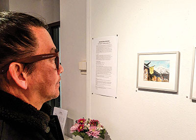 Mario Carlos, who teaches art at Forest Park, views a watercolor painting by Yingxue Zuo.
