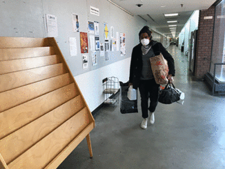 Forest Park student Micah Mickles walks down the fourth-floor hallway in G Tower on April 2. St. Louis Community College moved fall classes online March 30 but allowed art students to pick up projects and supplies on a staggered schedule. (Photo by Teri Maddox)
