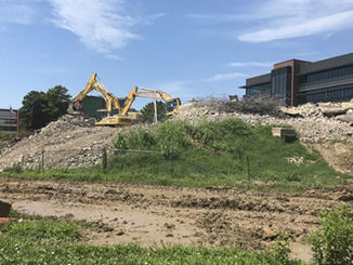 Above, A and B towers have been reduced to a pile of rubble, giving a full view of the new Center for Nursing and Health Sciences from College Drive. Below, the towers are shown on June 11, after windows had been removed to prepare for demolition.