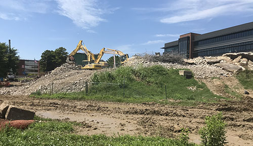 Above, A and B towers have been reduced to a pile of rubble, giving a full view of the new Center for Nursing and Health Sciences from College Drive. Below, the towers are shown on June 11, after windows had been removed to prepare for demolition.