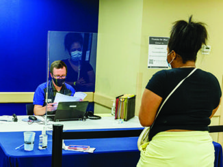 Philip Teare, financial aid campus manager at STLCC Forest Park, assists Brittni Hubbard, 20, studying radiology technology, with financial aid documents. (Photo by Fred Ortlip)
