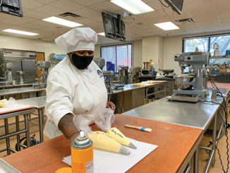 Culinary arts major Chasitty Crawley prepares pastry bags of dough for a class in the Hospitality Studies kitchen at Forest Park. (Photo by Casaan Whitney)
