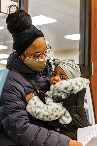 Vernisha Jones, 28, a second-semester nursing student at Forest Park, waits outside the admissions office with her daughter Zoe, who just turned 1. (Photo by Fred Ortlip)