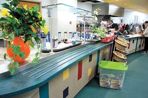Elements of the former cafeteria, including the tray counter, remain amid items for sale in the new Forest Park bookstore. (Photo by Leilani England)