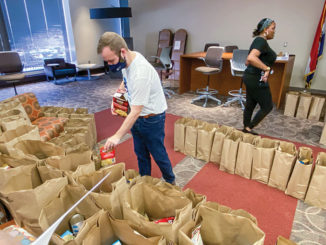 Representatives of Forest Park admissions and recruitment organized a Thanksgiving food distribution in November for students in need. Admissions counselor Edmond O’Neil, left, places mash potato mix into a bag in the Highlander Lounge. At right is Kimberly Banner, an admissions employee. (Photo by Markell Tomkins)